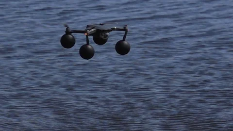 Quadcopter in slow motion hovering over water Stock Footage 125875007