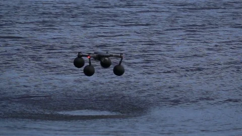 Quadcopter in slow motion hovering over water Stock Footage 125875221