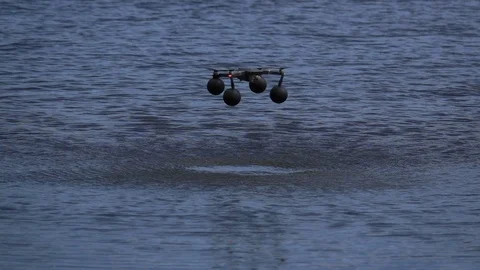 Quadcopter in slow motion hovering over water Stock Footage 125875298