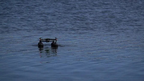 Quadcopter in slow motion hovering over water Stock Footage 125875340