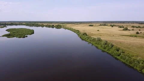 The quadcopter takes off over the bend of the river Stock Footage 139768566