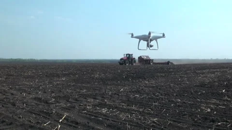 Quadcopter. Takes a video of the tractor in the field Stock Footage 106930640