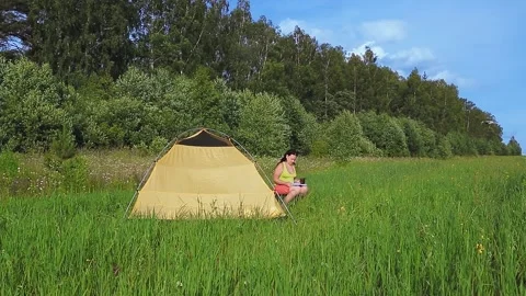 Quadcopter with tracking function flying over which woman is drinking tea with a Video stock 136564840