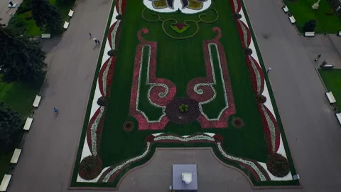 Quadcopter view of a huge flower bed in the park. A lot of people walk in the Video stock 93588069