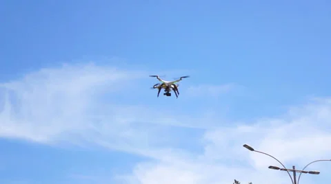 Quadrocopter on blue sky background go on a landing. Stock Footage 37914687