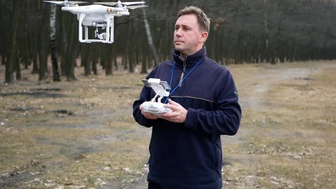 Quadrocopter drone operator pilot controls the UAV. Drone in flight. Modern tech Video stock 107807766