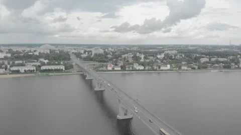 A quadrocopter flies over a bridge over a river in Old Russia, cars drive over Video stock 306146331