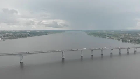 A quadrocopter flies over a bridge over a river in Old Russia, cars drive over Stock Footage 306146349