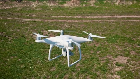 Quadrocopter flies over the field in slow motion (120 fps). Drone close-up. Stock Footage 74408733