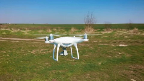 Quadrocopter flies over the field in slow motion (90 fps). Drone close-up. Stock Footage 74409078