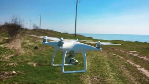 Quadrocopter flies over the field in slow motion (120 fps). Drone close-up. Stock Footage 74409541