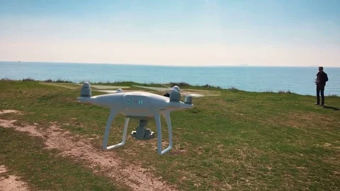 Quadrocopter flies over the field in slow motion (90 fps). Drone close-up. Stock Footage 74409752