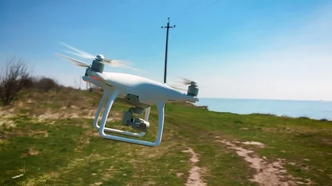 Quadrocopter flies over the field in slow motion (120 fps). Drone close-up. Stock Footage 74409978