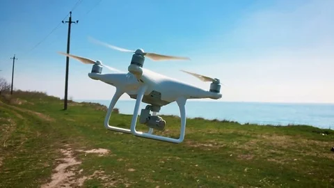 Quadrocopter flies over the field in slow motion (120 fps). Drone close-up. Stock Footage 74410061