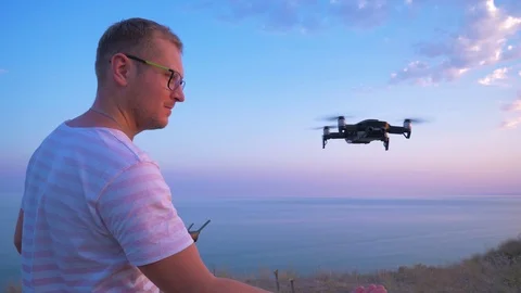 Quadrocopter flies over the man's head and lands on his hand. Slow motion in 4K. Stock Footage 93996345