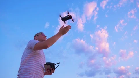 Quadrocopter flies over the man's head and lands on his hand. Slow motion in 4K. Stock Footage 93996980