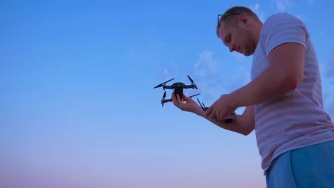 Quadrocopter flies over the man's head and lands on his hand. Slow motion in 4K. Stock Footage 93997196