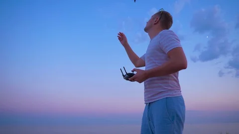 Quadrocopter flies over the man's head and lands on his hand. Slow motion in 4K. Stock Footage 93997247
