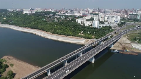 A quadrocopter hovering above a wide river and bridge in the city. Stock Footage 127893467