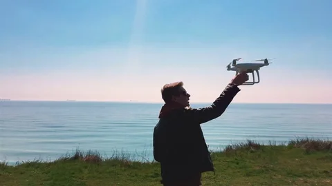 Quadrocopter lands on the pilot's hand. The pilot catches the drone. Slow motion Stock-Footage 74410181