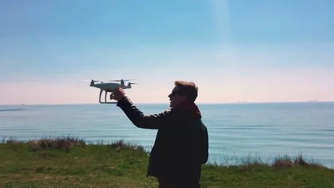 Quadrocopter lands on the pilot's hand. The pilot catches the drone. Slow motion Stock Footage 74410243
