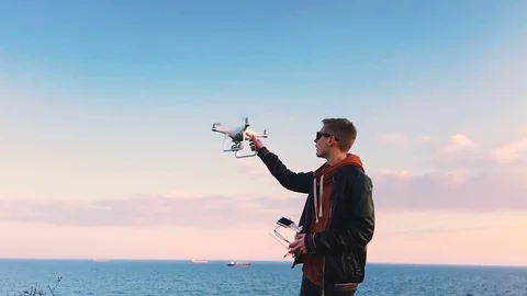 Quadrocopter lands on the pilot's hand. The pilot catches the drone. Slow motion Stock Footage 74795276