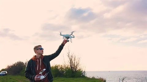 Quadrocopter lands on the pilot's hand. The pilot catches the drone. Slow motion Stock Footage 74795886
