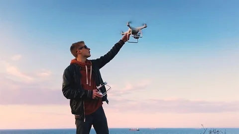 Quadrocopter lands on the pilot's hand. The pilot catches the drone. Slow motion Stock Footage 74795944