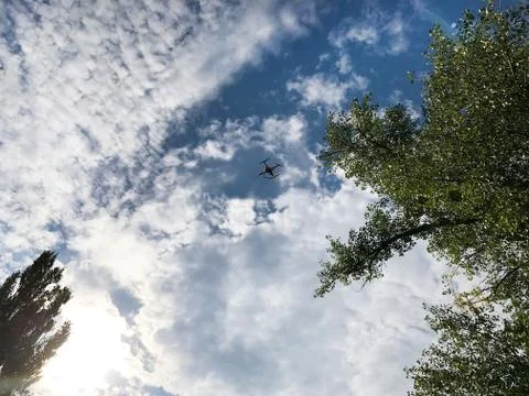 Quadrocopter in the sky with clouds. Stock Photos
