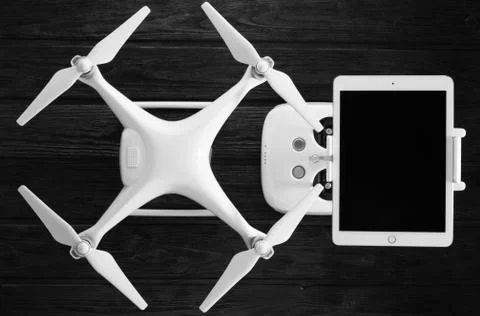 Quadrocopter, tablet and remote control on a black wooden background Stock Photos