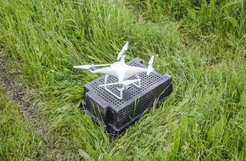 Quadrocopters on a plastic box in the grass Stock Photos