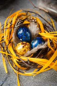 Quail easter eggs with feathers in nest on brown table with copy space. Foto stock