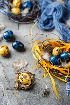 Quail easter eggs with feathers in nest on brown table with copy space. Foto stock