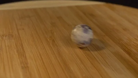 Quail egg spinning on a cutting board. Slow motion Stock Footage 72643754
