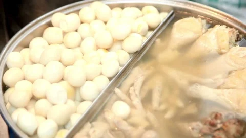 Quail eggs and chicken boiling in a large street food pot Stock Footage 336230220