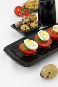 Quail eggs and tomatoes Stock Photos