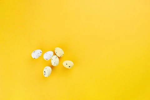 Quail eggs are different lie on a yellow background.  Top view, empty space Stock Photos