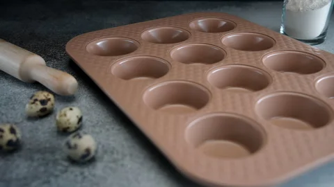 Quail Eggs Beside Muffin Baking Tray and Rolling Pin on Kitchen Counter Stock Footage 273701080
