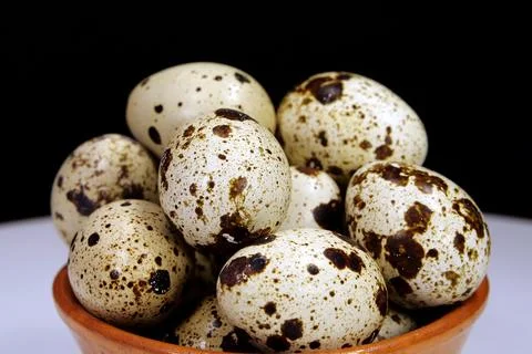 Quail eggs on black background, close-up shot Foto stock