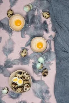 Quail eggs in ceramic vases, gray feathers on the table, easter still life, Stock Photos