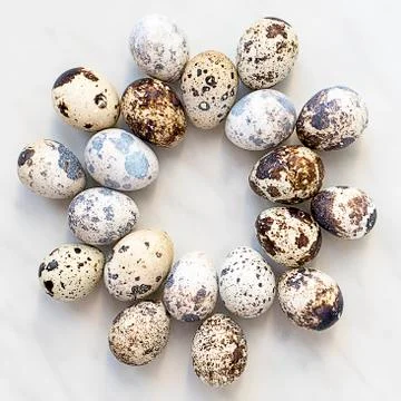 Quail eggs on a marble surface in the form of a round pattern Foto stock
