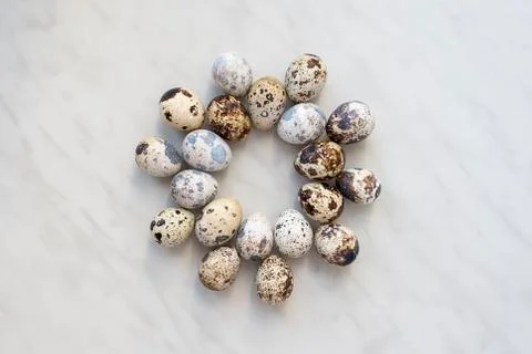 Quail eggs on a marble surface in the form of a round pattern 写真素材