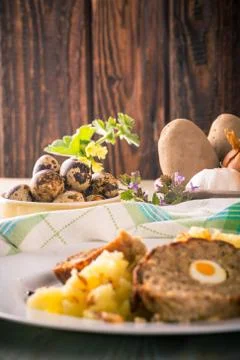 Quail eggs next to portion of meatloaf on white plate with mashed potatoes Stock Photos
