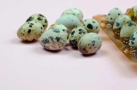 Quail eggs in a package on a pink background Stock Photos