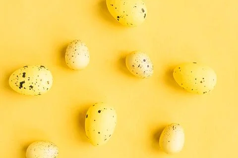 Quail eggs pattern on bright yellow background. Easter festive background 스톡 사진