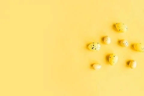 Quail eggs pattern on bright yellow background. Easter festive background. Co Stock Photos