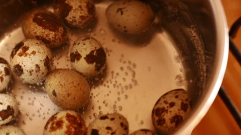 Quail eggs under boiling water surface Stock Footage 73975184