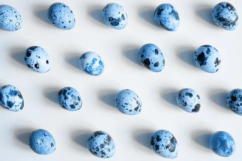 Quail eggs on a white background. a regular pattern. toned classic blue color Stock Photos