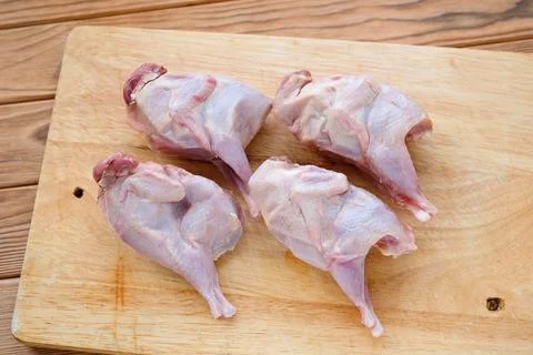 Quails on a cutting board. Thawed poultry preparing for cooking Stock Photos