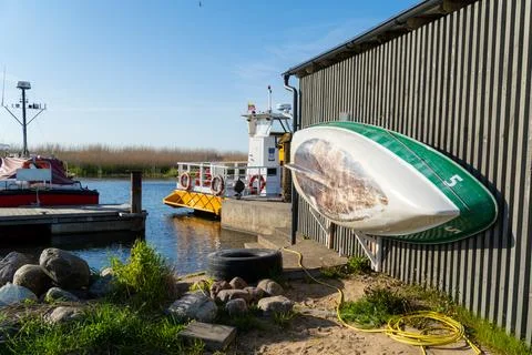 Quaint harbor scene with an upside-down small boat on a rustic wooden shed,.. Foto stock